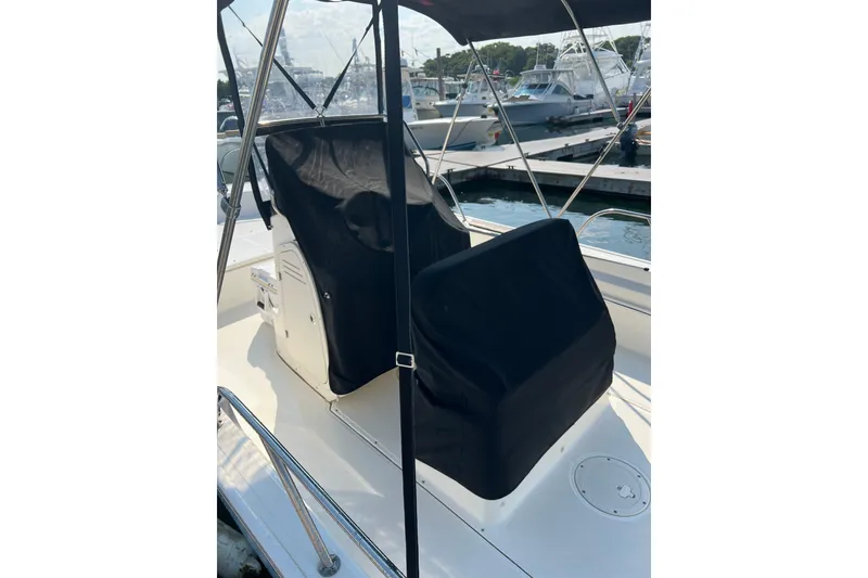 Slide: The Image of 2021 Boston Whaler 190 Montauk boat interior with covered seating at marina. - 6