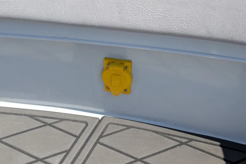 Slide: The Image of Yellow outlet on 2022 Encore Boat Works 28, mounted on white interior panel. - 14