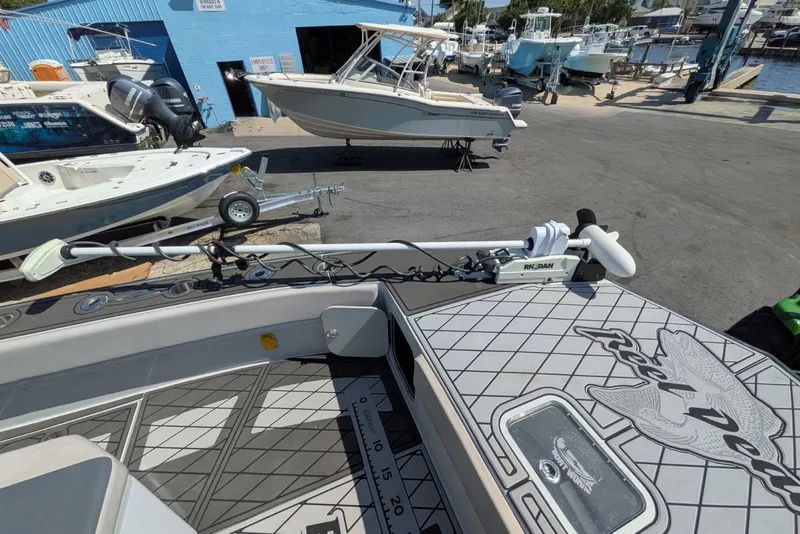 Slide: The Image of 2022 Encore Boat Works 28 at marina with trolling motor and custom deck design. - 10