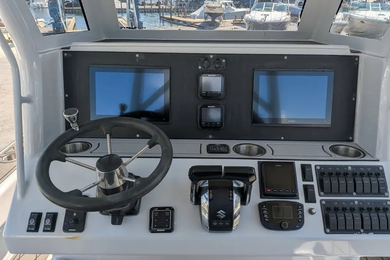 Slide: The Image of Helm of 2022 Encore Boat Works 28 with dual screens and controls. - 8