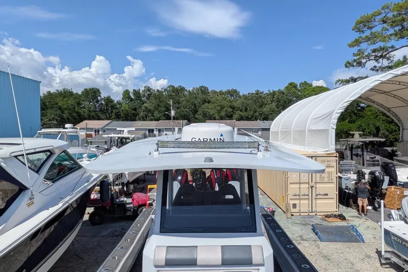 Slide: The Image of 2022 Encore Boat Works 28 docked, featuring Garmin equipment, surrounded by other boats and storage. - 7