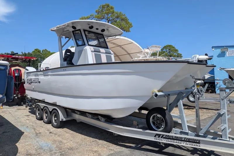 Slide: The Image of 2022 Encore Boat Works 28 on trailer, parked outdoors under clear blue sky. - 2