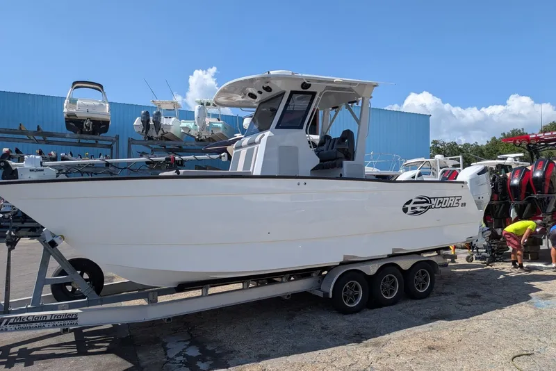 The Image of 2022 Encore Boat Works 28 on trailer, parked outdoors under clear blue sky. - 1