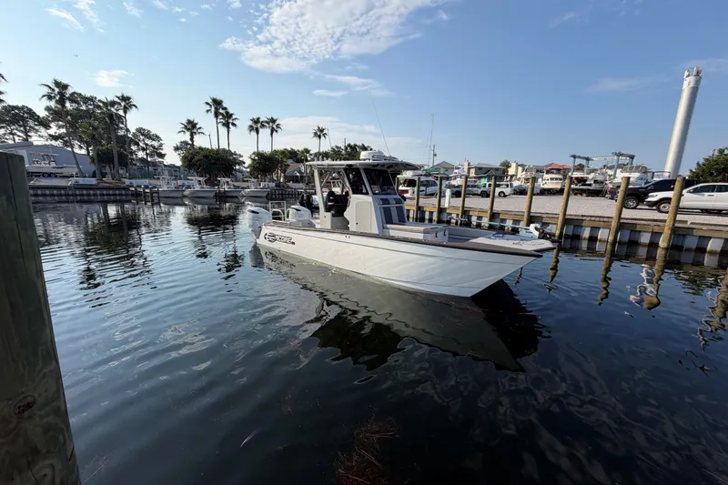 The Image of 2022 Encore Boat Works 28 docked in a marina with palm trees and clear skies. - 0