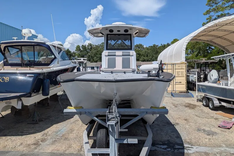 Slide: The Image of 2022 Encore Boat Works 28 on trailer, surrounded by other boats in a marina setting. - 3