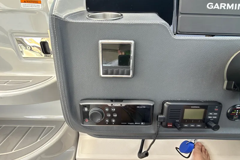 Slide: The Image of 2019 Regal 33 XO boat dashboard with Garmin and Fusion audio controls. - 17