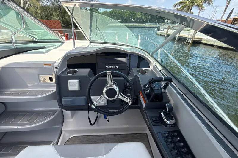 Slide: The Image of 2019 Regal 33 XO boat helm with Garmin navigation, docked by water. - 16