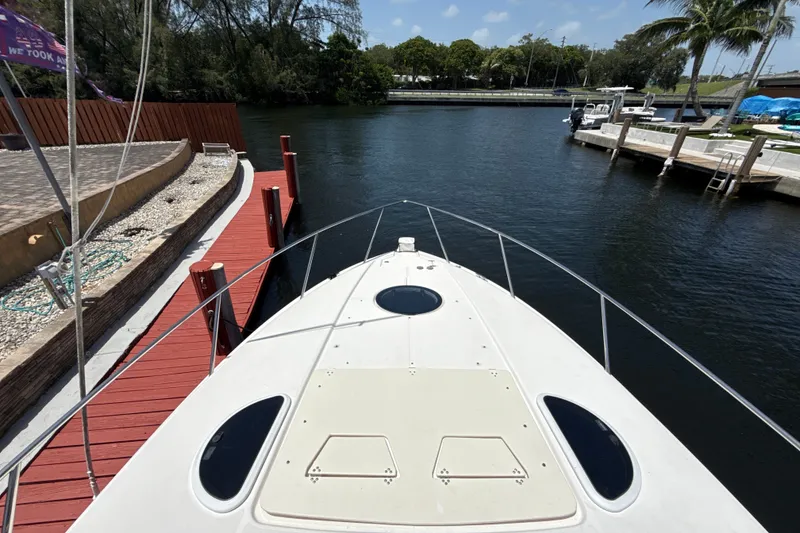 Slide: The Image of Bow view of a 2019 Regal 33 XO yacht docked by a serene waterfront. - 31