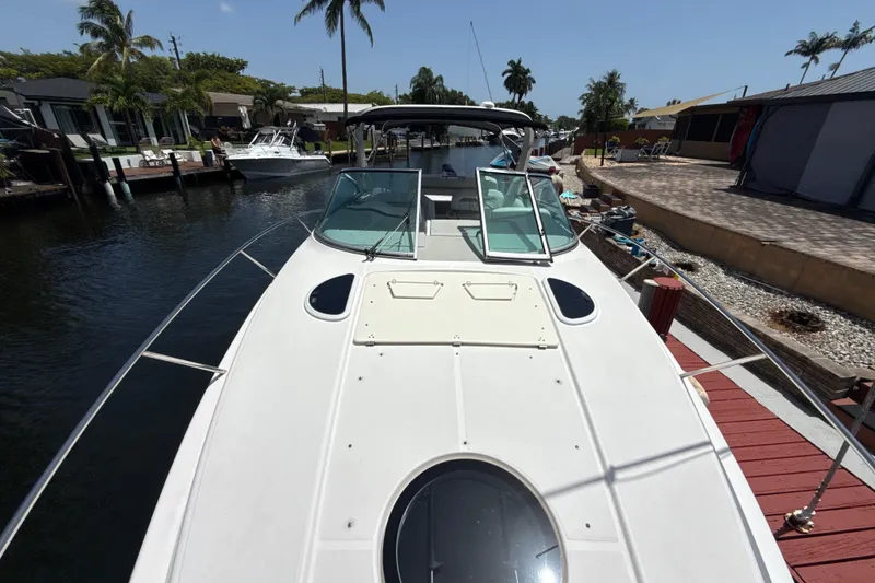 Slide: The Image of 2019 Regal 33 XO boat docked in a sunny canal with palm trees. - 33