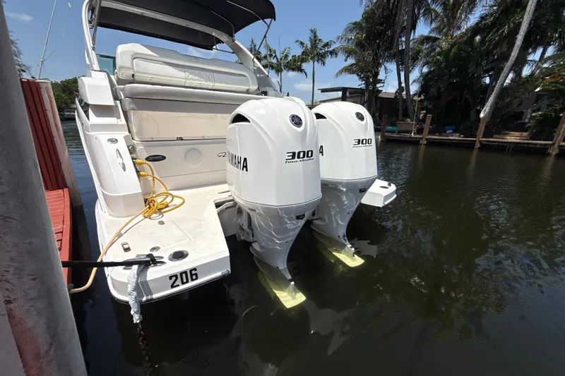 Slide: The Image of 2019 Regal 33 XO boat with twin Yamaha 300 engines docked by palm trees. - 4