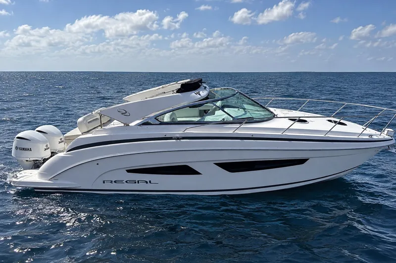Slide: The Image of 2019 Regal 33 XO boat on open sea with Yamaha engines, under clear blue sky. - 3