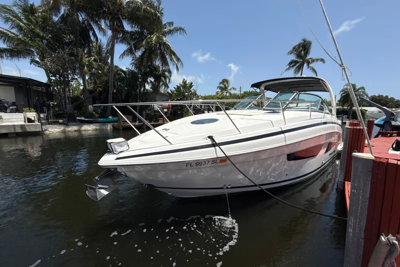 Slide: The Image of 2019 Regal 33 XO boat docked in a tropical marina setting. - 5