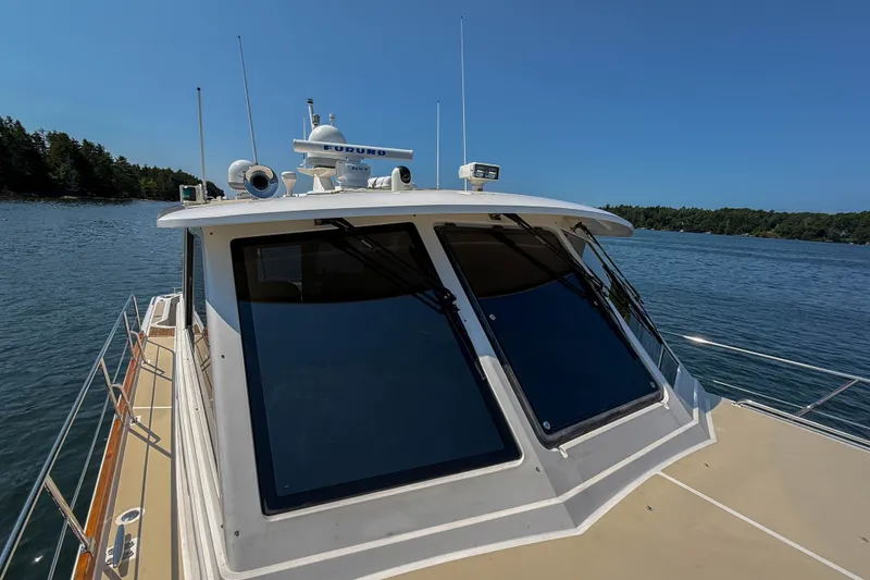 Slide: The Image of 2008 Grand Banks 45 Eastbay SX yacht on calm water, showcasing sleek design and advanced navigation equipment. - 52