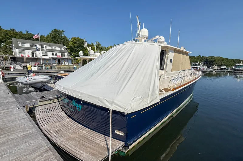 Slide: The Image of 2008 Grand Banks 45 Eastbay SX yacht docked at a marina, covered with a protective tarp. - 61