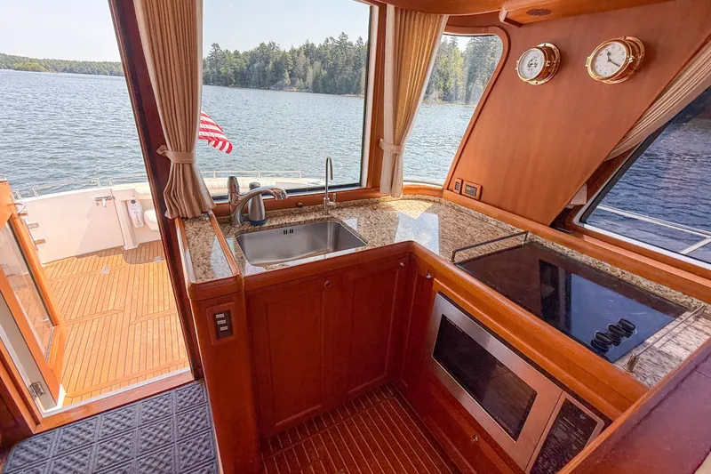 Slide: The Image of Luxurious 2008 Grand Banks 45 Eastbay SX yacht interior with kitchen and scenic lake view. - 16