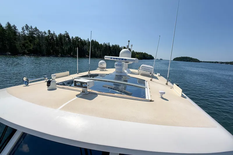 Slide: The Image of 2008 Grand Banks 45 Eastbay SX yacht cruising on a serene lake with lush forested shores. - 53