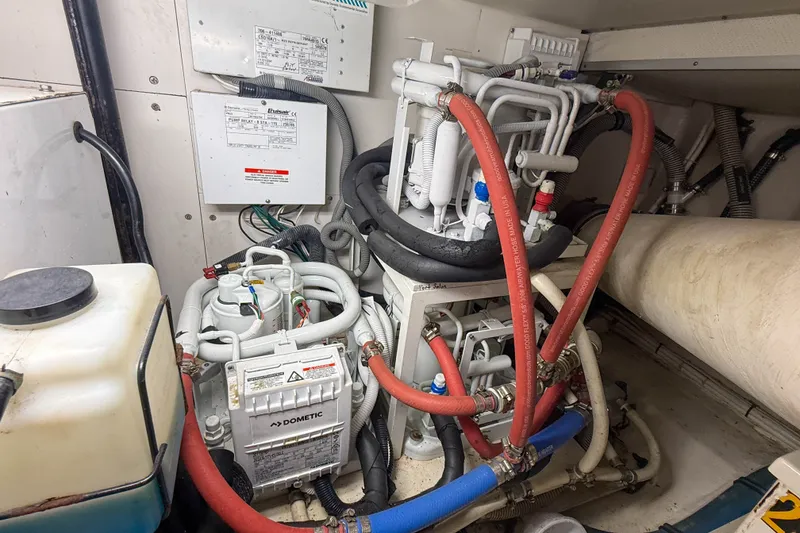 Slide: The Image of Engine room of a 2008 Grand Banks 45 Eastbay SX with Dometic equipment and red hoses. - 57