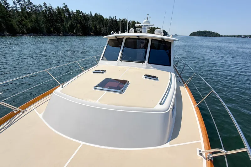 Slide: The Image of 2008 Grand Banks 45 Eastbay SX yacht on calm water, surrounded by lush trees. - 51