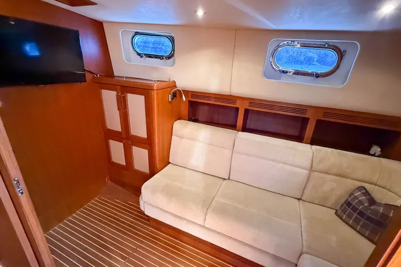 Slide: The Image of Luxurious interior of 2008 Grand Banks 45 Eastbay SX with sofa, TV, and porthole window. - 38
