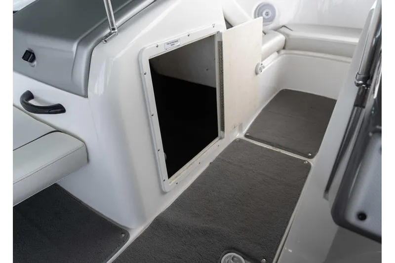 Slide: The Image of 2015 Yamaha Boats AR190 interior storage compartment with open hatch and gray carpeted flooring. - 11