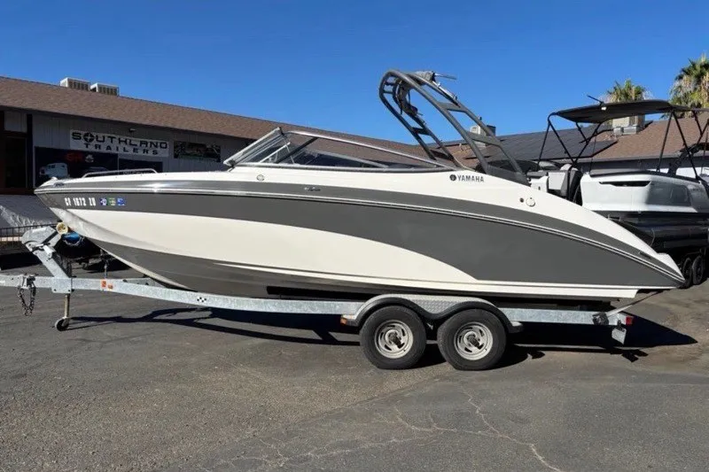 Slide: The Image of 2015 Yamaha Boats AR240 HO on trailer, parked outdoors under clear blue sky. - 1