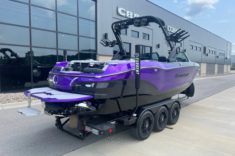 Slide: The Image of 2023 MasterCraft X24 boat in vibrant purple, parked outside a modern building. - 4