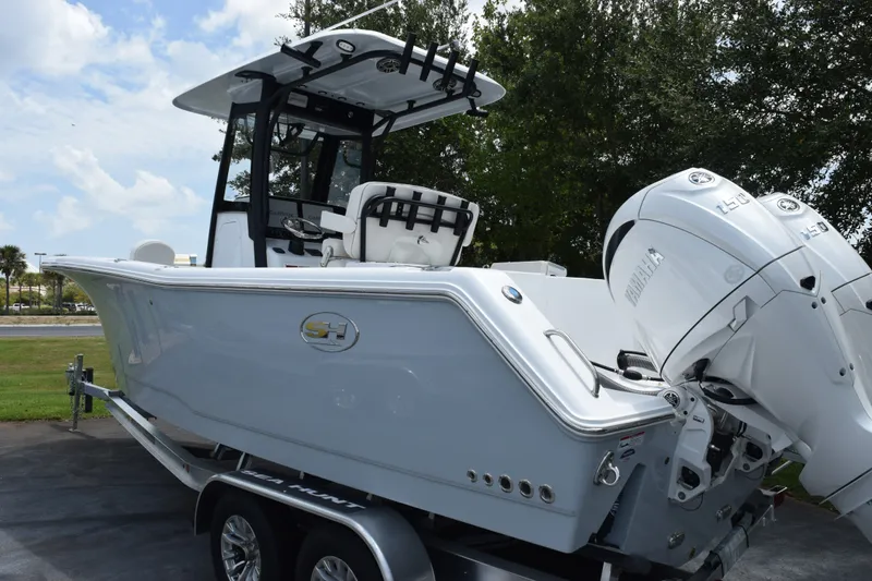 Slide: The Image of 2027 Sea Hunt Gamefish 25 boat with dual Yamaha engines on a trailer. - 4