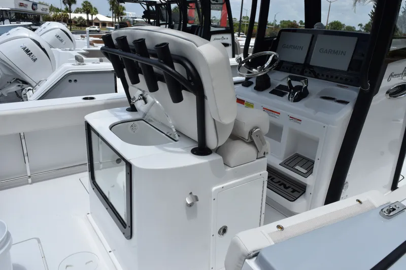 Slide: The Image of 2027 Sea Hunt Gamefish 25 boat interior with helm, rod holders, and Garmin displays. - 6