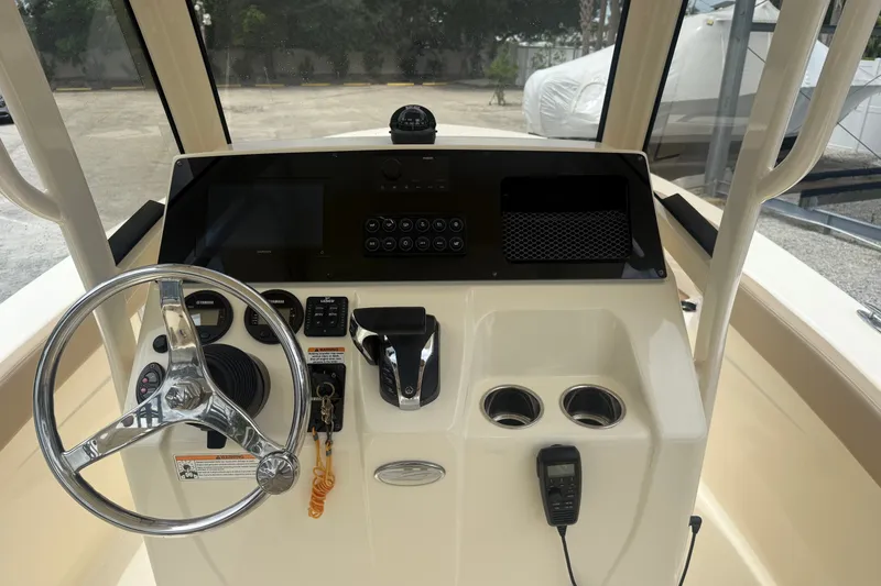 Slide: The Image of 2024 Scout 215 XSF boat dashboard with steering wheel and control panel. - 6