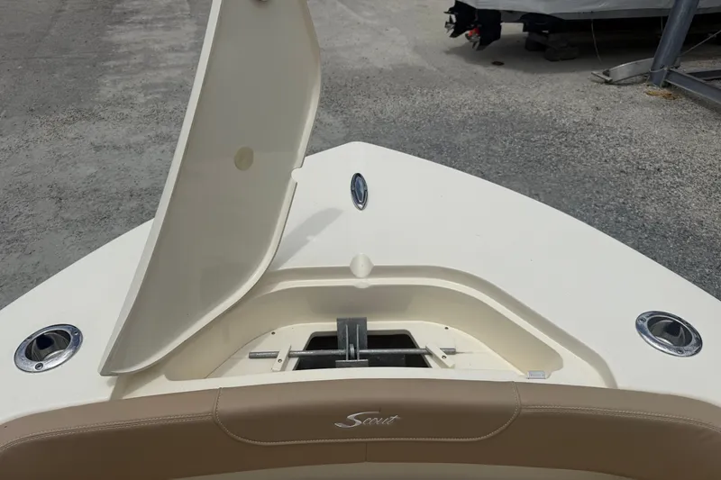Slide: The Image of 2024 Scout 215 XSF boat bow with open storage compartment and sleek design. - 13