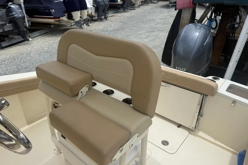 Slide: The Image of 2024 Scout 215 XSF boat interior with tan seating and Yamaha outboard motor. - 9