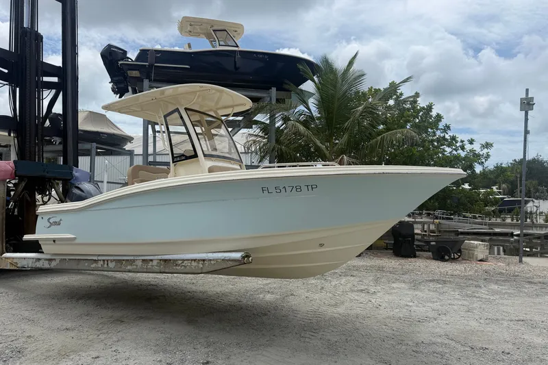 Slide: The Image of 2024 Scout 215 XSF boat on lift, outdoor setting, cloudy sky background. - 2