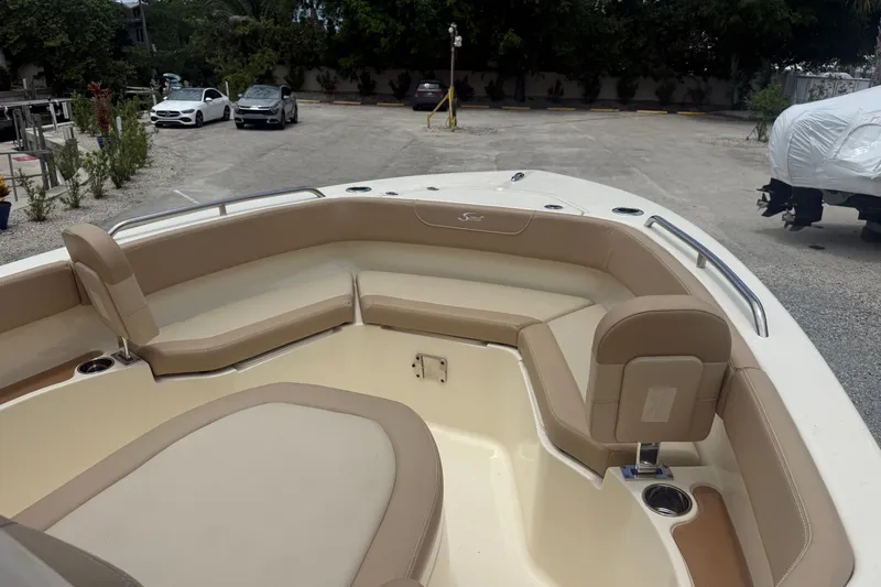 Slide: The Image of 2024 Scout 215 XSF boat interior with beige seating and cup holders. - 11