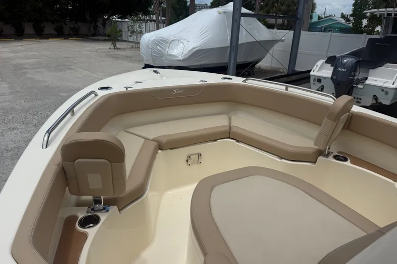 Slide: The Image of 2024 Scout 215 XSF boat interior with beige seating and cup holders. - 10