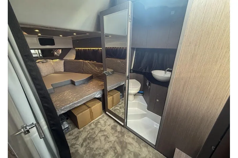 Slide: The Image of Interior of 2026 Beneteau Flyer 10 Sport Top, featuring cozy cabin and compact bathroom. - 15