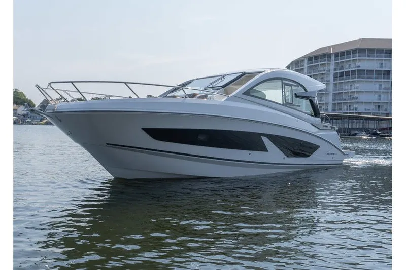 Slide: The Image of 2026 Beneteau Flyer 10 Sport Top cruising on calm waters near modern buildings. - 4