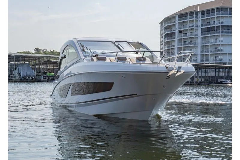 Slide: The Image of 2026 Beneteau Flyer 10 Sport Top boat cruising near waterfront buildings. - 2