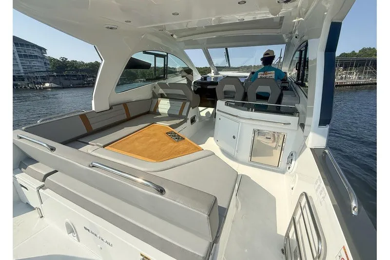 Slide: The Image of 2026 Beneteau Flyer 10 Sport Top boat interior with seating and helm, docked by the water. - 7