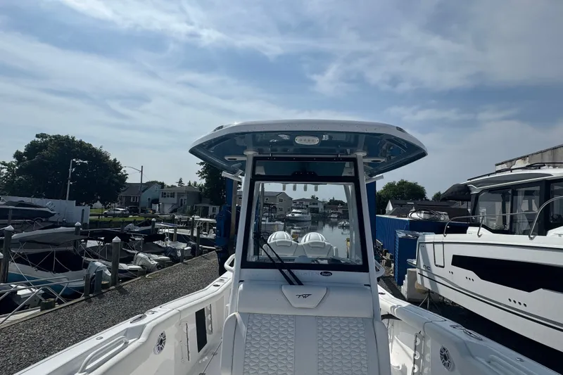 Slide: The Image of 2027 Tidewater 272 LXF boat docked at a marina under a cloudy sky. - 22