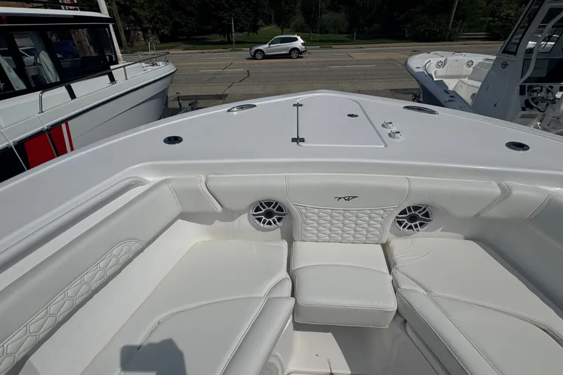 Slide: The Image of 2027 Tidewater 272 LXF boat interior with white cushioned seating and speaker system. - 20