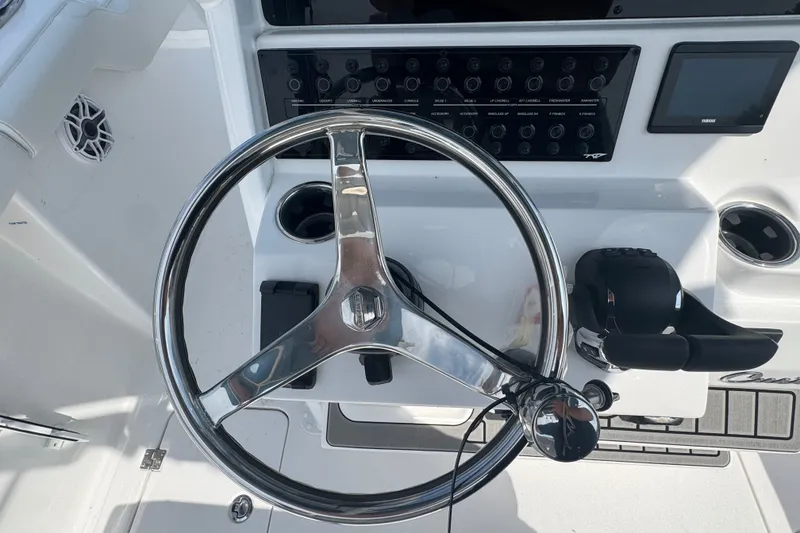 Slide: The Image of Steering wheel and controls of a 2027 Tidewater 272 LXF boat cockpit. - 15