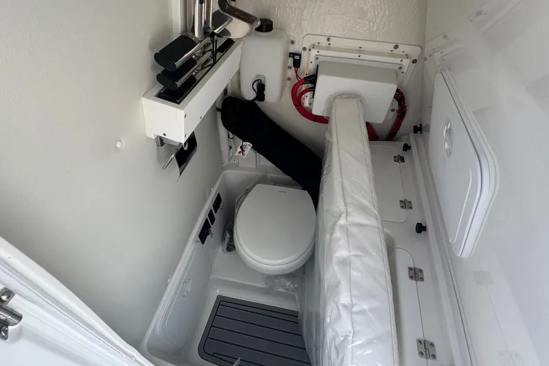 Slide: The Image of Interior of 2027 Tidewater 272 LXF boat featuring compact marine toilet setup. - 18