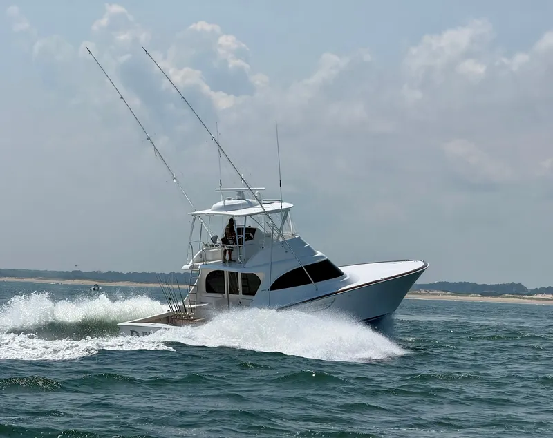 Slide: The Image of A 2027 Viking 50 Billfish speeds through the water, with fishing rods on deck. - 2
