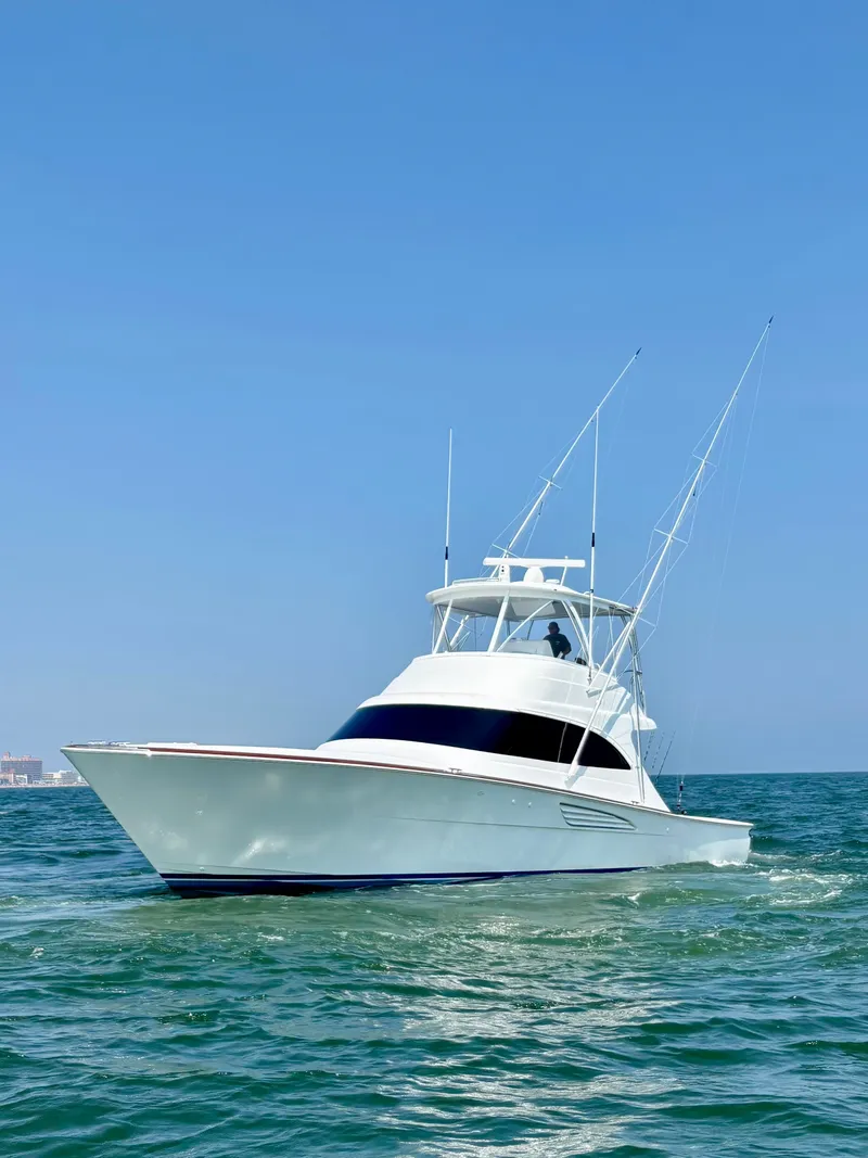 Slide: The Image of A sleek, modern boat with two masts cruising on calm waters under a clear sky. - 5
