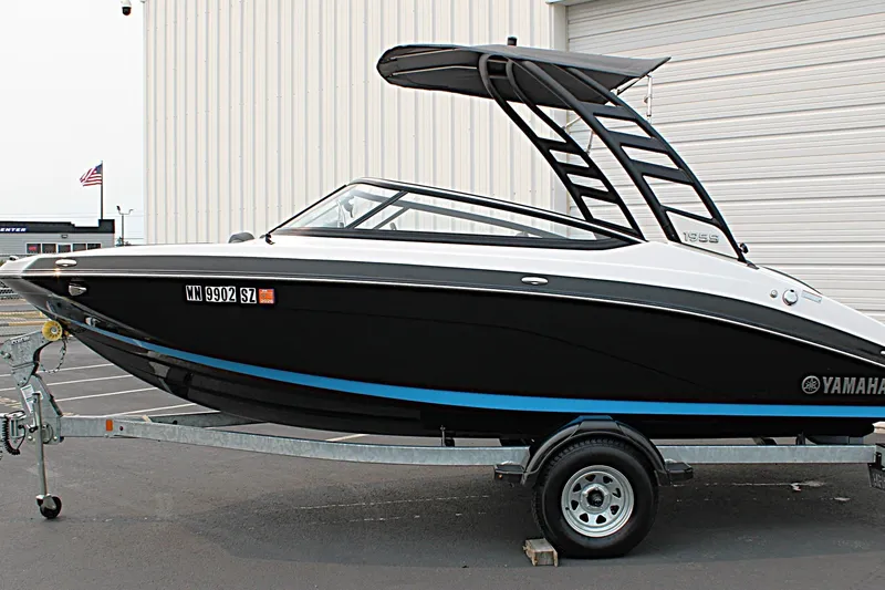 Slide: The Image of 2022 Yamaha Boats 195S on trailer, black and white design, parked outdoors. - 3