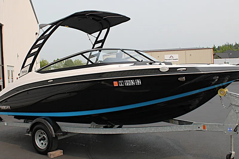Slide: The Image of 2022 Yamaha Boats 195S on trailer, sleek black design, parked outdoors. - 8