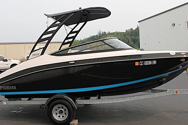 Slide: The Image of 2022 Yamaha Boats 195S on trailer, black and white design, parked outdoors. - 7