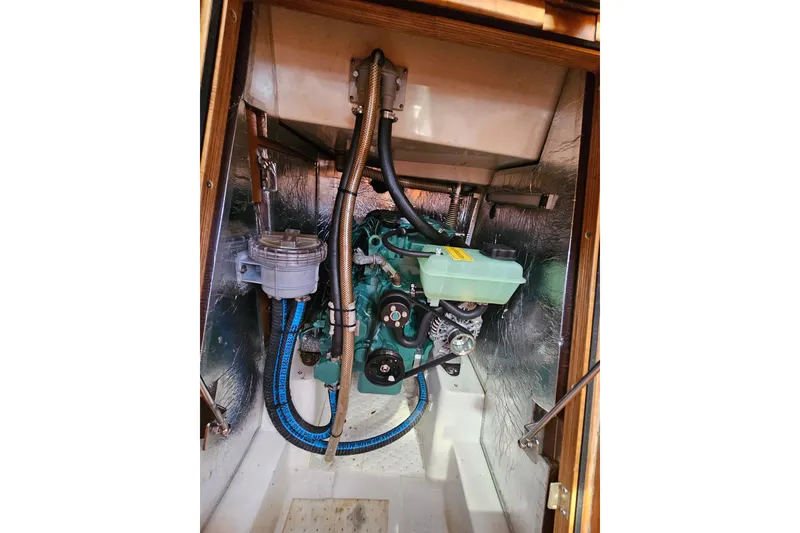 Slide: The Image of Engine compartment of 2015 X-Yachts Xc 38, showcasing mechanical components and hoses. - 18