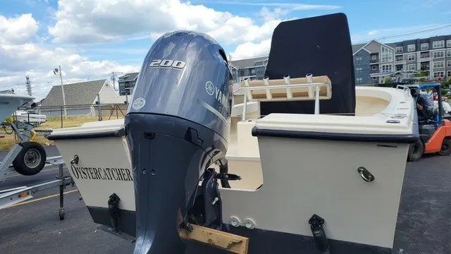 Slide: The Image of A 2004 Parker 23 Special Edition boat with a Yamaha 200 outboard motor, parked in a lot. - 4