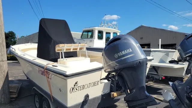 Slide: The Image of A 2004 Parker 23 Special Edition boat with a Yamaha outboard motor, parked on a trailer. - 2